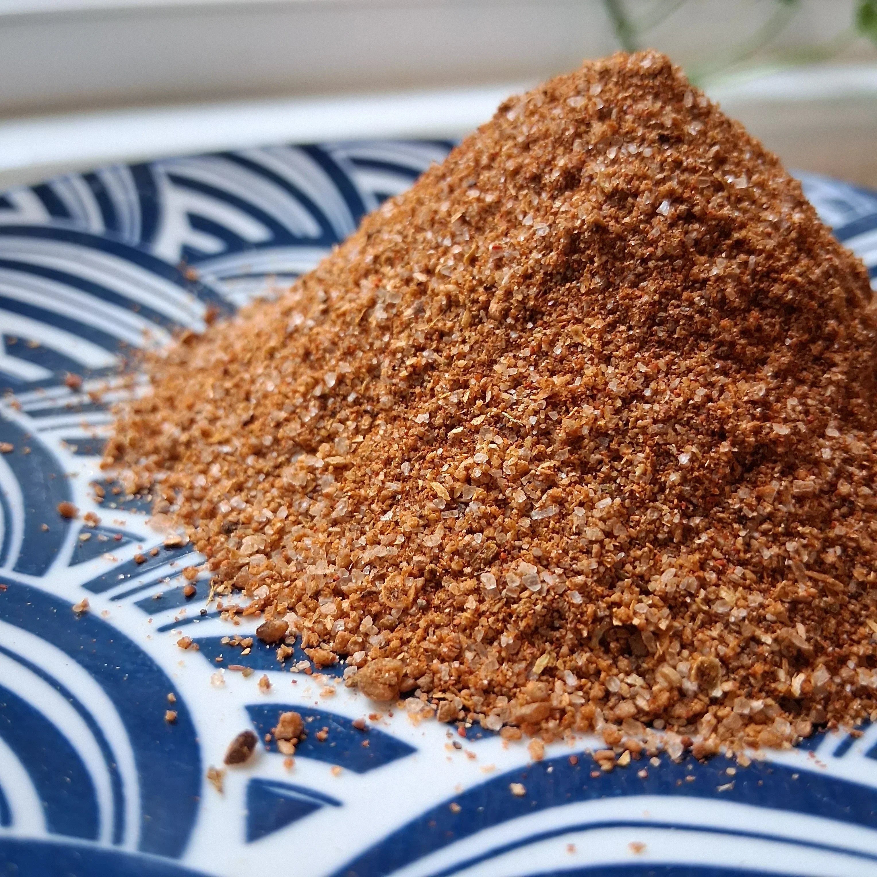 A pile of fresh ground Lucky Cajun seasoning showing the coarse texture and rich color of small-batch Cajun blend used to season a seafood boil like the ocean