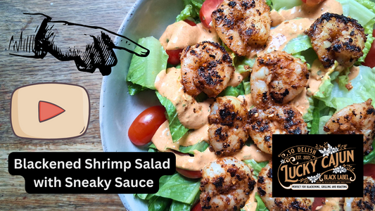 Plate of blackened shrimp salad with romaine lettuce, cherry tomatoes, and a drizzle of Cajun remoulade sauce (Sneaky Sauce) on top
