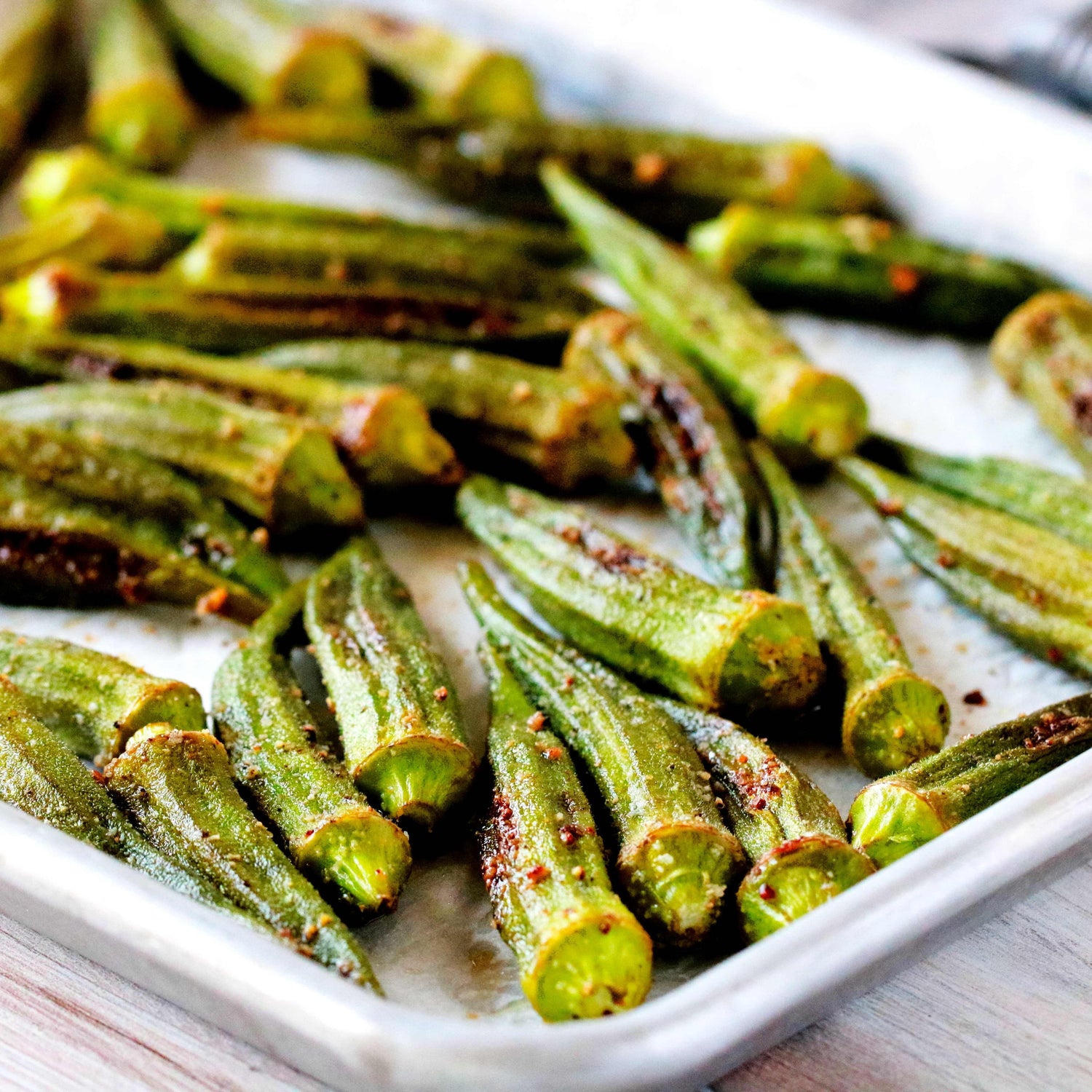 Roasted okra tomatoes and onions on a plate seasoned with Lucky Cajun Black Label fresh ground Cajun seasoning showing the caramelization and depth that par-roasting vegetables builds before they go into a holiday casserole