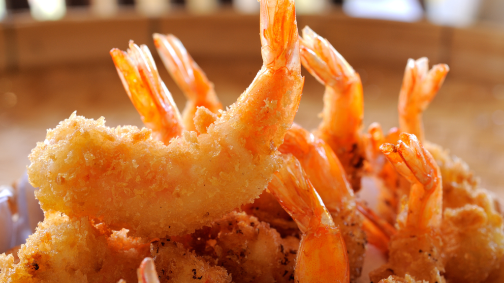 Golden fried shrimp with a crisp cornmeal crust seasoned with Lucky Cajun Black Label showing the Southern fry technique done in cast iron