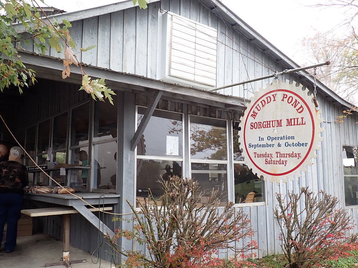 Rustic wooden Mud Pond Sorghum Mill store sign representing the traditional Southern sorghum syrup used in the country ham glaze recipe from the No-BS Holiday Cookbook by Chef Blackwell Smith