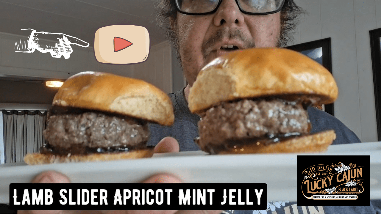Lamb burger sliders on brioche buns topped with homemade apricot mint jelly made with Lucky Cajun Greek Out fresh ground Mediterranean herb seasoning showing juicy lamb patties