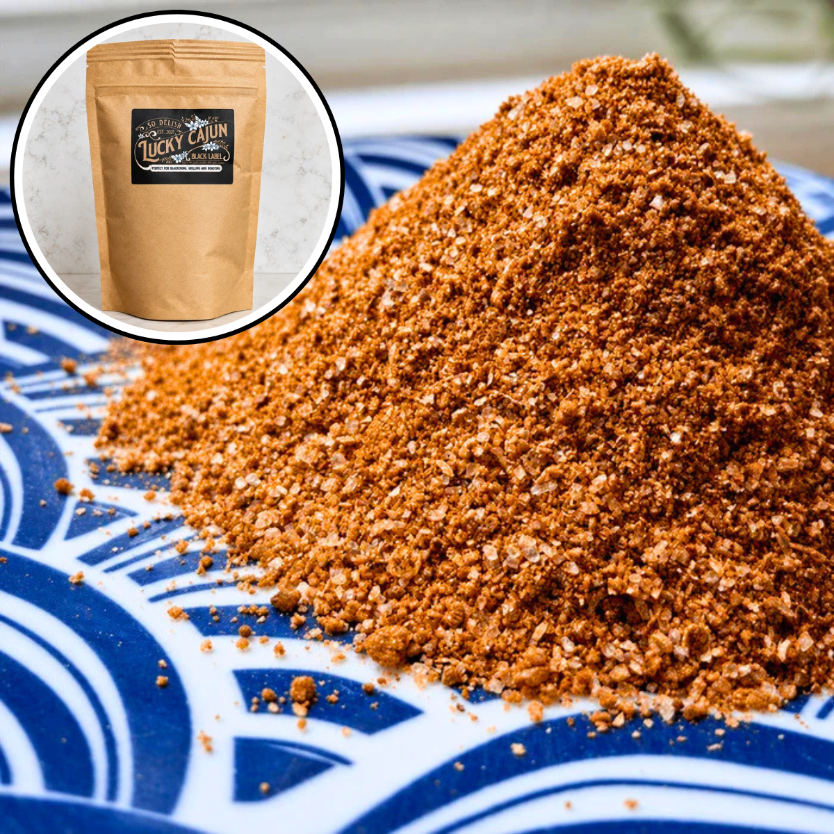 A close-up of a mound of coarse brown seasoning or spice blend on a blue-and-white patterned plate, with a circular inset showing a kraft pouch labeled Lucky Charms Seasoning.