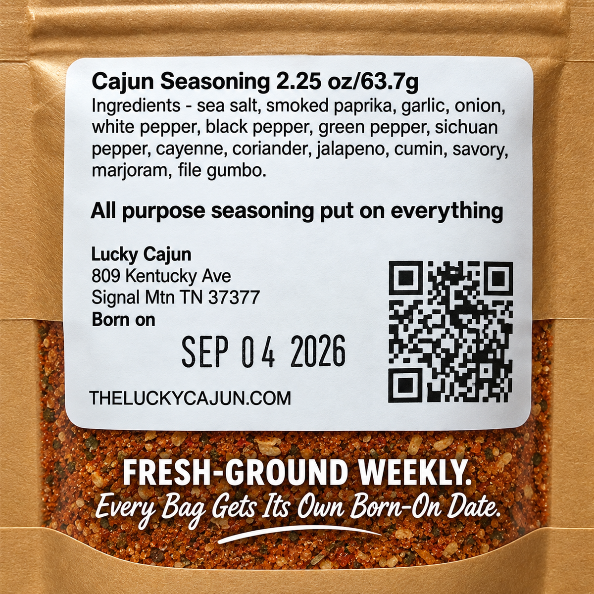 A close-up of a Lucky Cajun seasoning packet showing the front label with product details, a QR code, and visible ground seasoning through the clear lower section of the kraft paper bag.