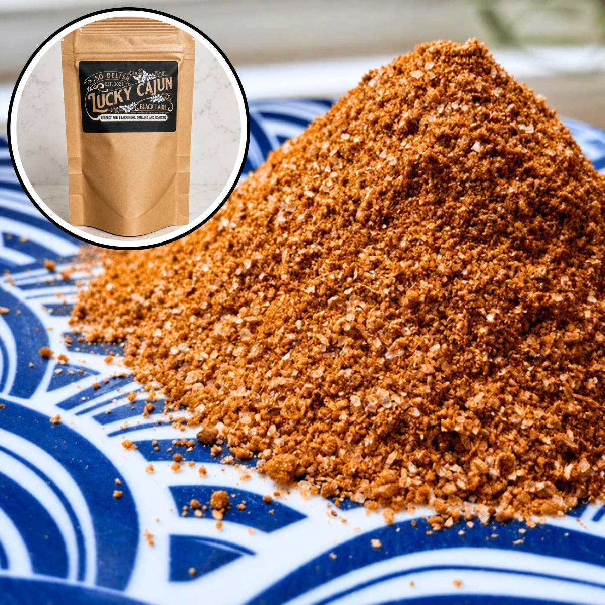 A close-up of a mound of coarse orange-brown seasoning or spice blend on a blue-and-white patterned plate, with a circular inset showing a kraft pouch labeled Lucky Caution.