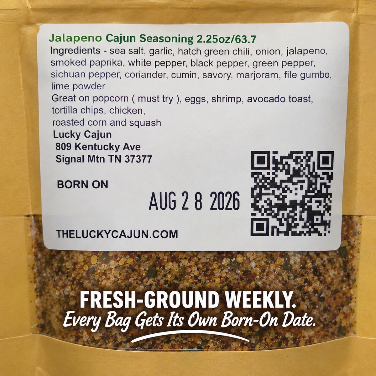 Front label of a bag of Lucky Cajun Seasoning showing the product name, ingredients list, location address, birth date, QR code, and a window revealing the ground spice mix inside.