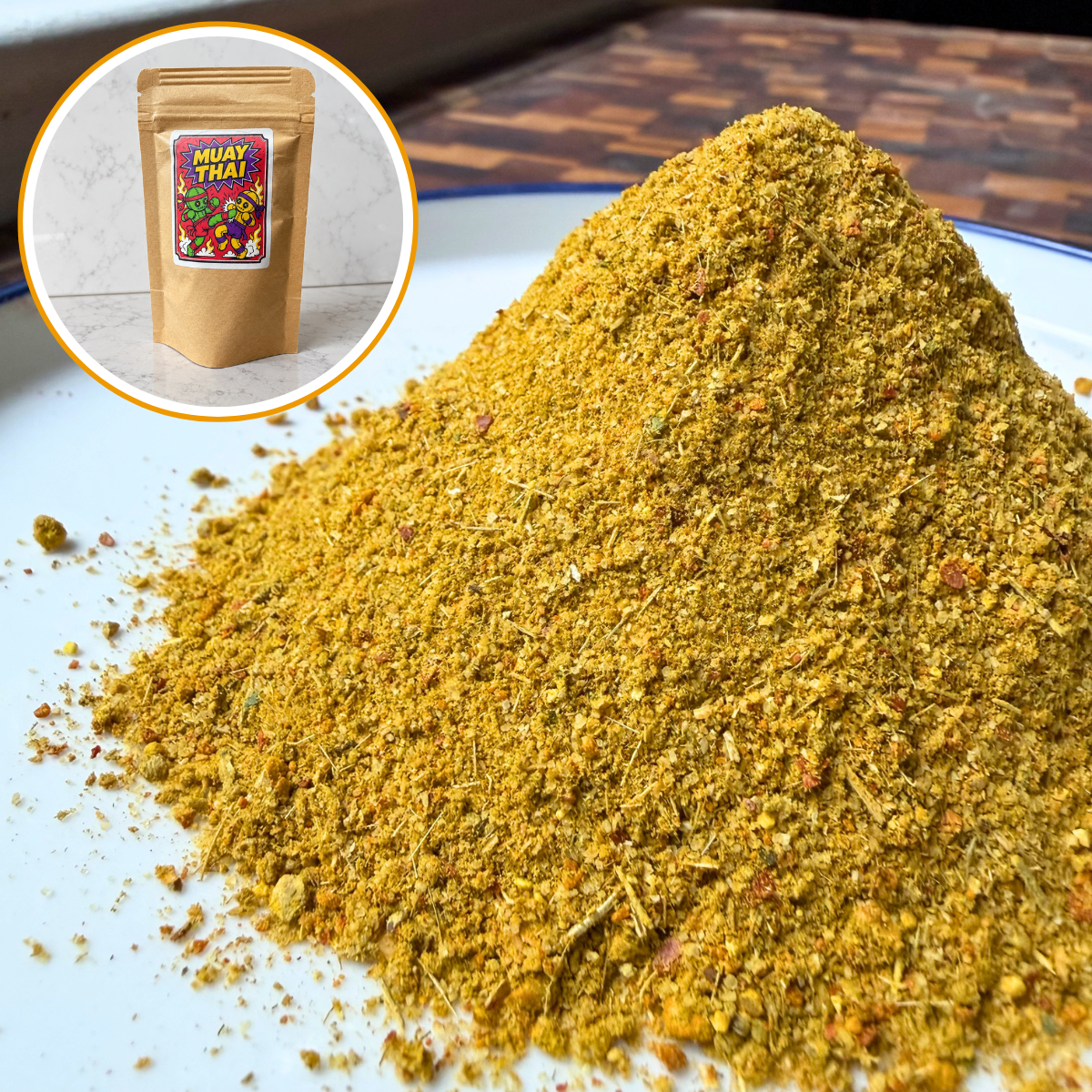 A mound of ground Muay Thai spice blend in golden-brown and yellow-green tones on a white plate, with a circular inset showing a kraft pouch labeled 'MUAY THAI'.