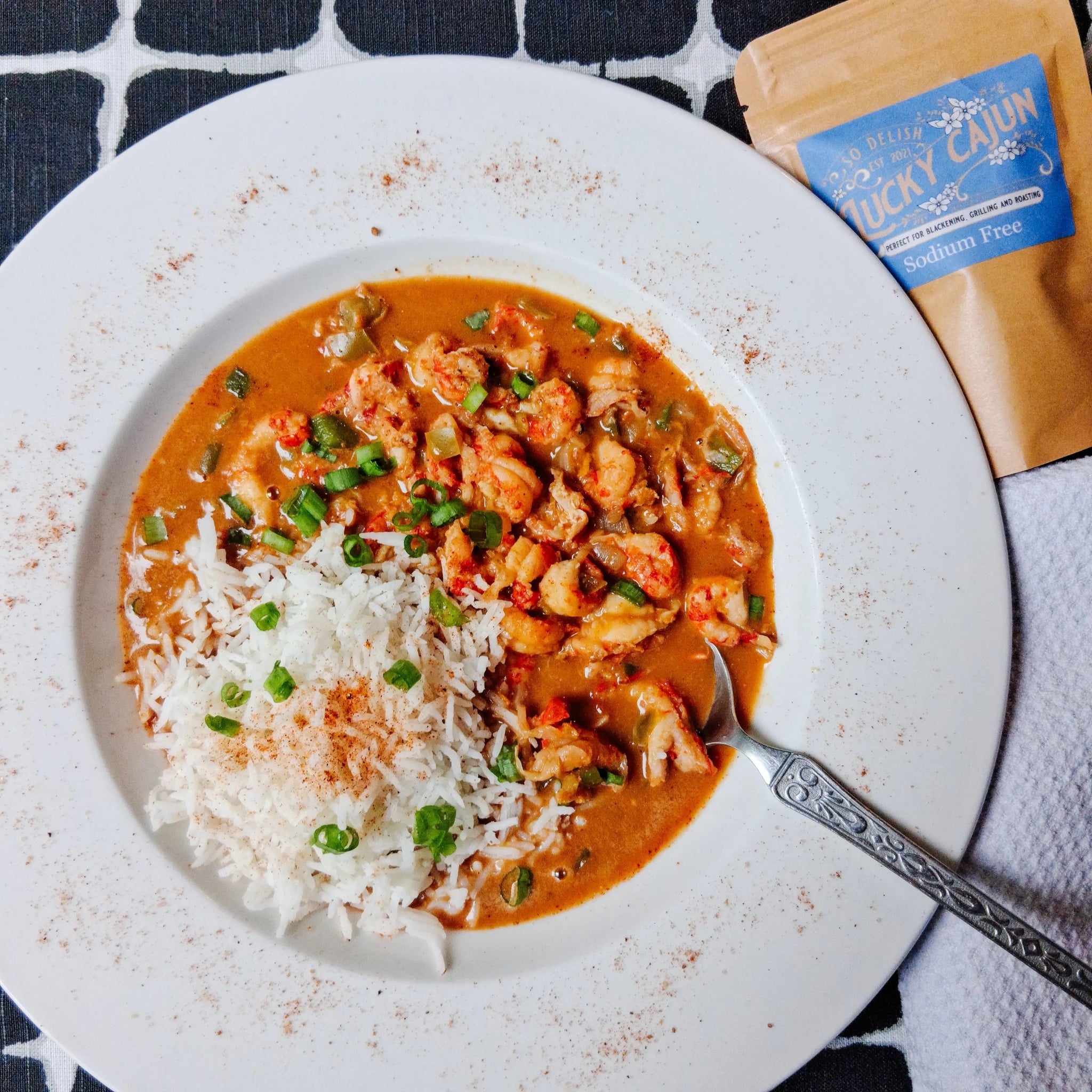 A bowl of crawfish étouffée over white rice, seasoned with Lucky Cajun Salt-Free Original—showing the rich, dark roux and vibrant color achievable without added sodium.