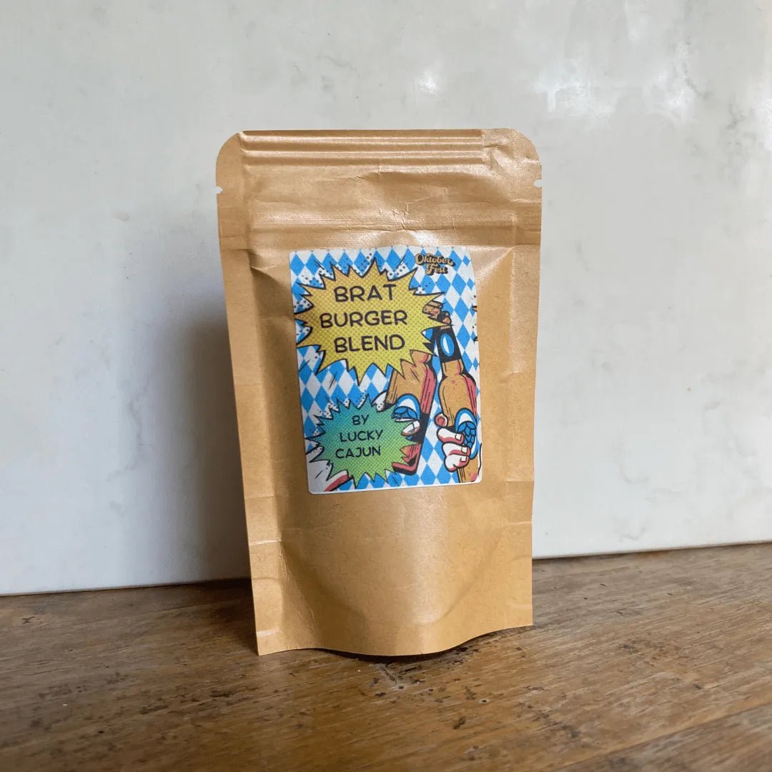 Brat Burger Blend seasoning pouch on a rustic wooden table—handcrafted with marjoram, ginger, and caraway for easy, homemade bratwurst patties with any ground meat.