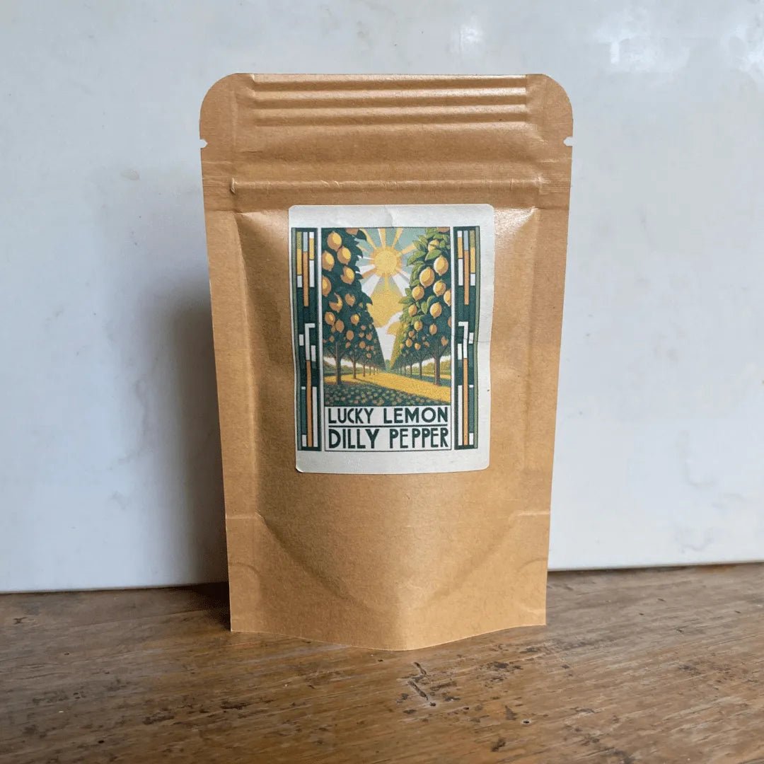Lucky Lemon Dilly Pepper seasoning pouch on a rustic wooden table—handcrafted with real lemon peel and aromatic dill for a fresh, zero-heat flavor profile.