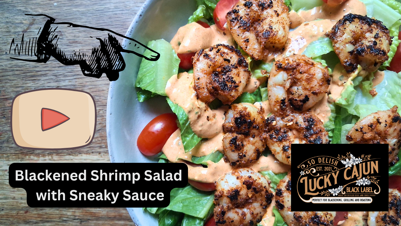 Plate of blackened shrimp salad with romaine lettuce, cherry tomatoes, and a drizzle of Cajun remoulade sauce (Sneaky Sauce) on top