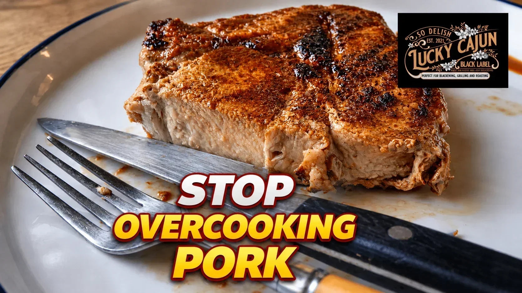 Thick-cut pork chop sliced open with a knife and fork showing a juicy pink center, cooked in cast iron with Lucky Cajun Blackened Scorpion seasoning.