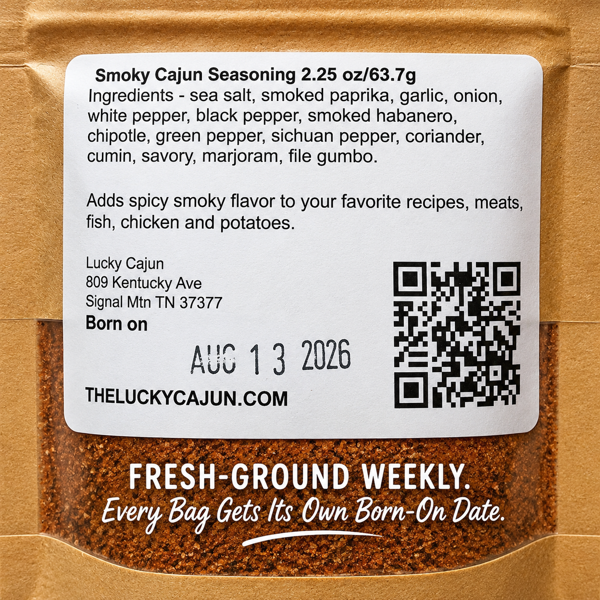 Close-up of a spice seasoning bag label reading 'Smokey Cajun Seasoning' with ingredients listed, a QR code, Lucky Cajun address, and a brown spice powder visible through the packaging.