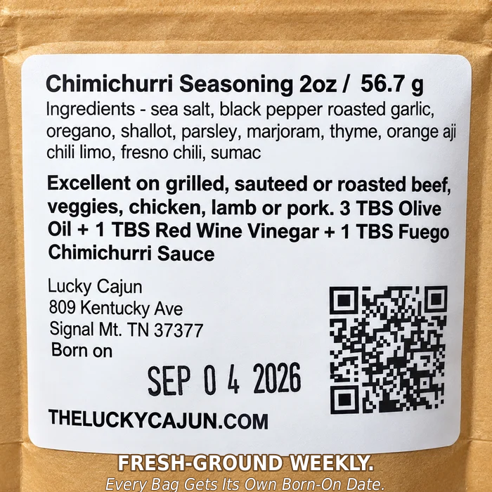 A close-up of a kraft paper bag with a white product label for Chimichurri Seasoning by Lucky Cajun. The label lists ingredients, serving suggestions, a handwritten date of SEP 04 2026, a QR code, and the website THELUCKYCAJUN.