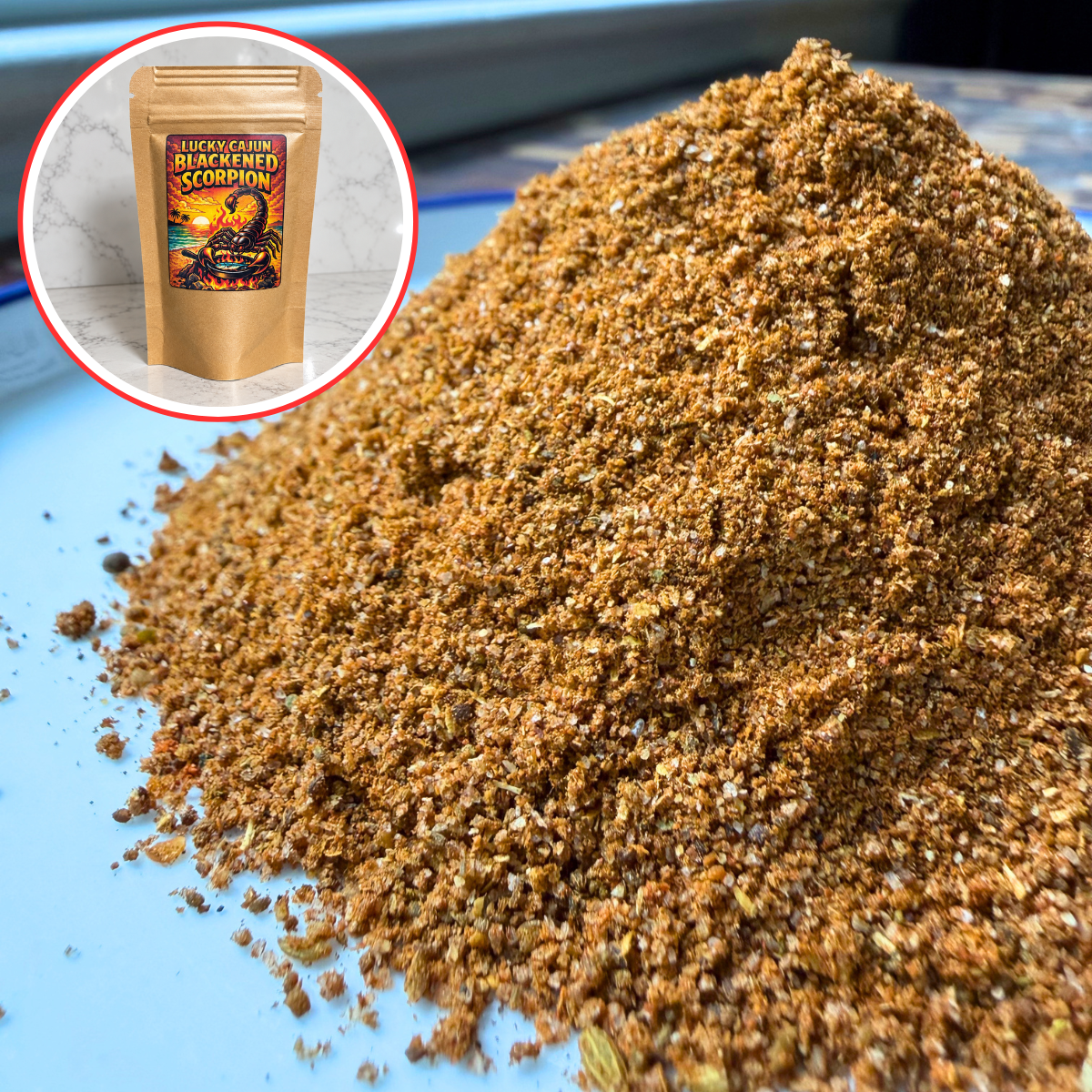 A pile of coarse brown spice blend or seasoning granules on a light blue surface, with a circular inset showing a kraft pouch labeled 'Hornet Fire Blackened Scorpion' seasoning mix.
