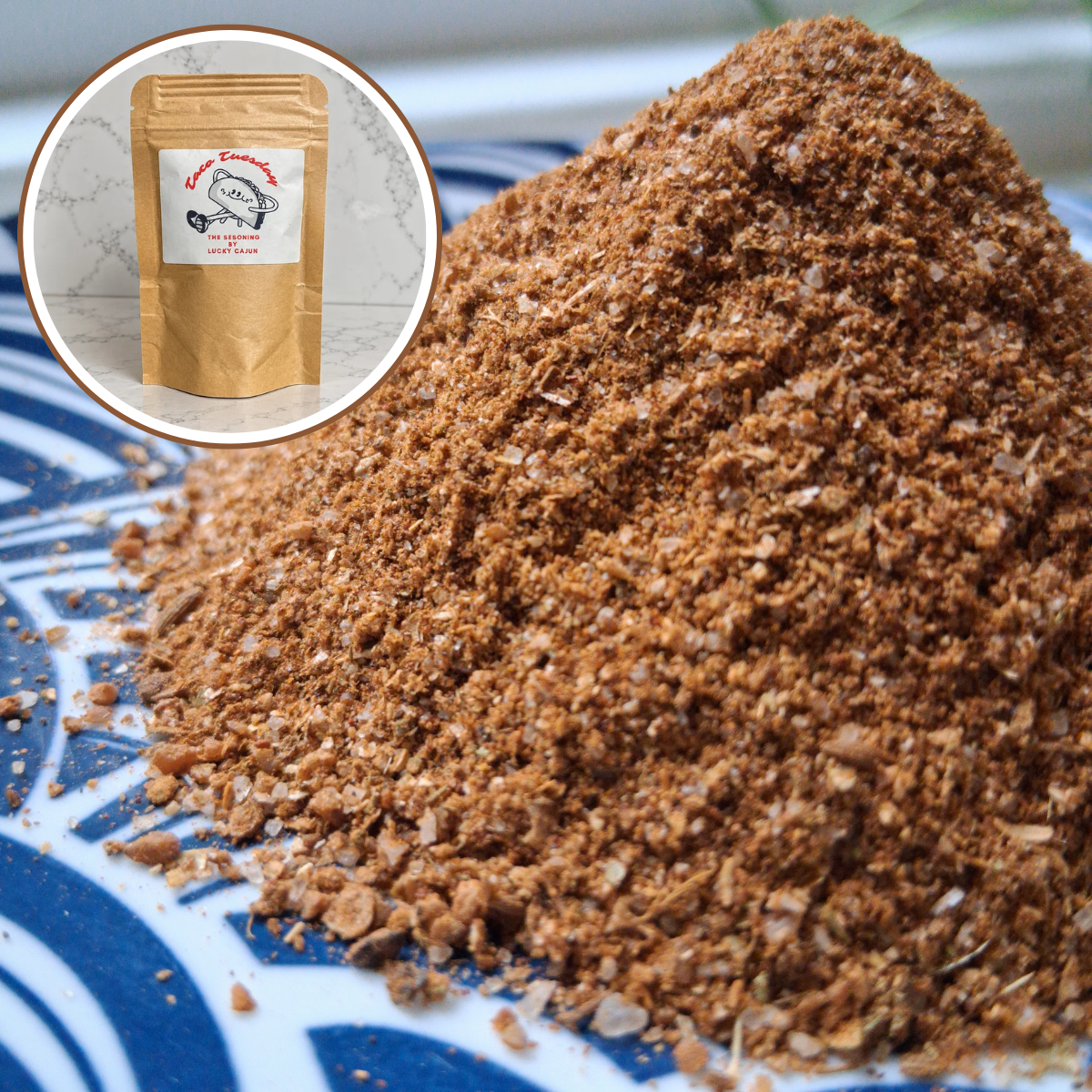 A close-up of a pile of brown ground coffee or spice blend on a blue and white patterned plate, with a circular inset showing a kraft paper pouch labeled 'Crazy Cow Coffee Roastery' on a marble surface.
