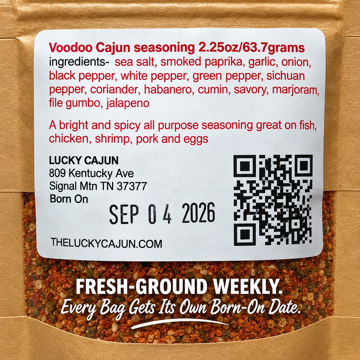 A bag of Lucky Cajun seasoning with a large white label showing the product name, ingredients, address, birth date, and QR code. The seasoning mix is visible through the clear window in the kraft paper bag.