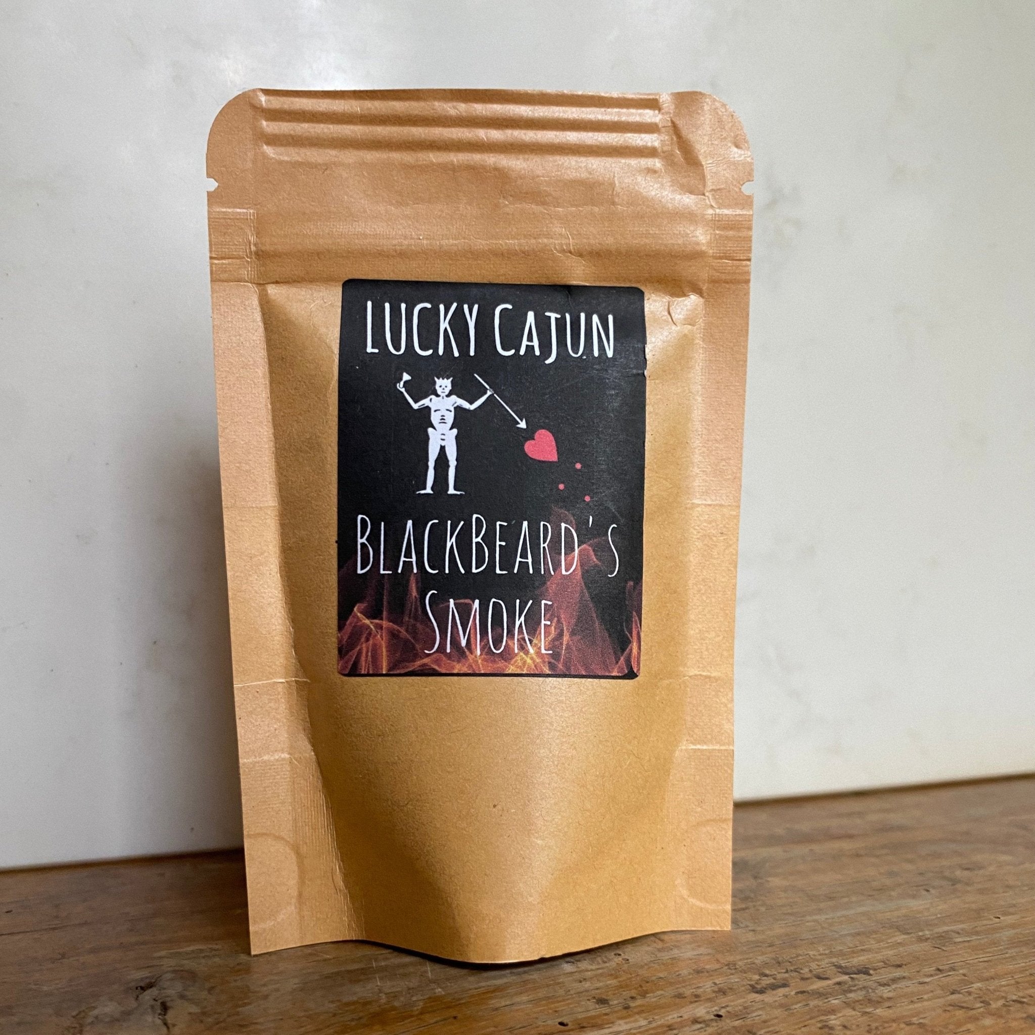 A pouch of Black Beard’s Smoke spicy Cajun seasoning on a table. Fresh-ground with smoked habanero and chipotle, featuring the Lucky Cajun Born On Date.