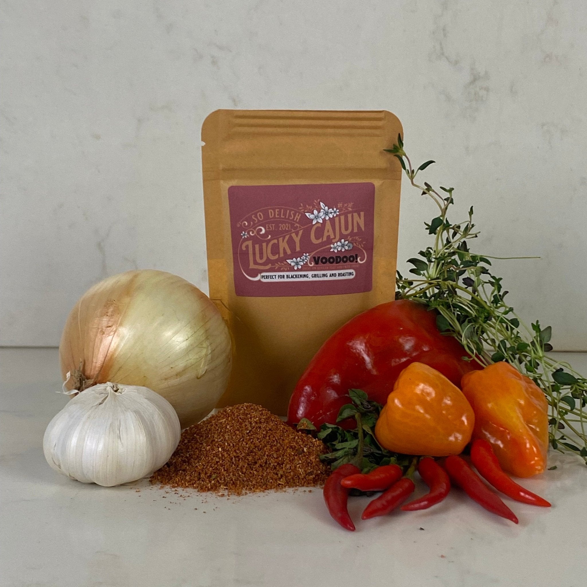 A pouch of Voodoo Enhanced Cajun seasoning with fresh peppers and garlic—the habanero-boosted evolution of our Black Label.