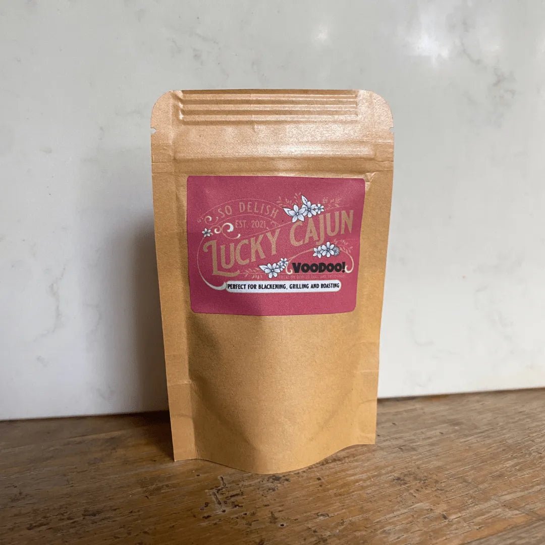 Lucky Cajun Voodoo seasoning pouch on a rustic wooden table—handcrafted and enhanced with habanero for bold, spicy flavor.