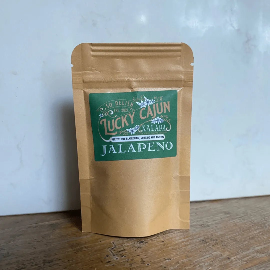Lucky Cajun Xalapa Jalapeño Seasoning in its signature light-blocking, air-reduction pouch, displayed on a rustic wooden table—the ultimate Human Artifact for fresh-ground flavor.
