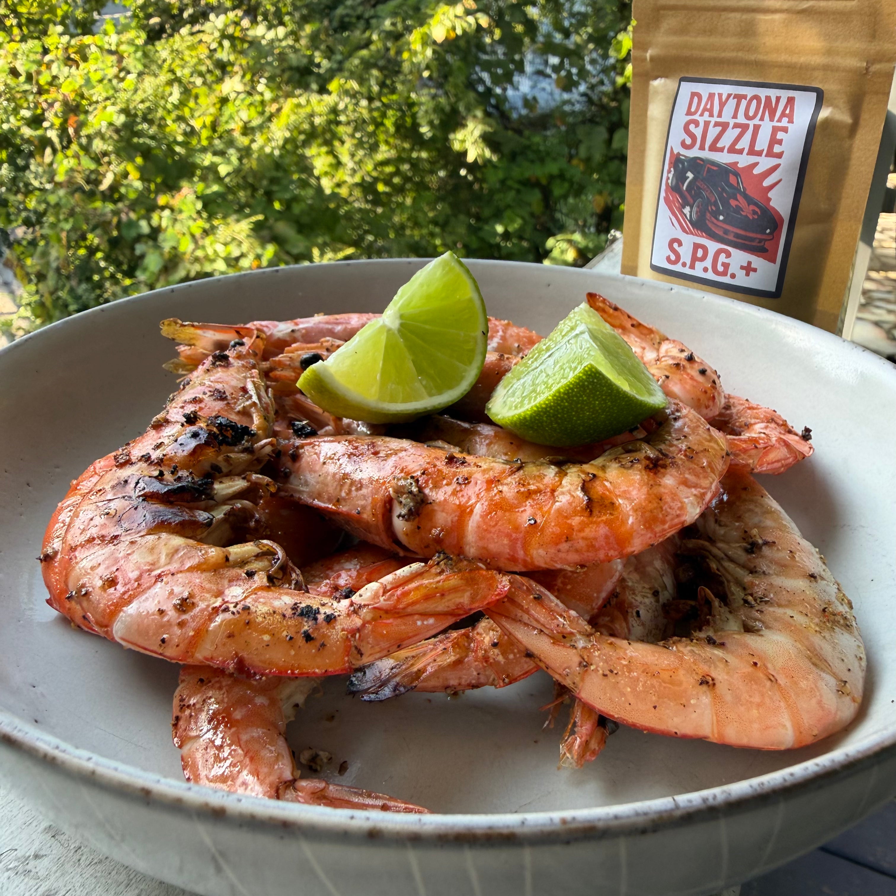 Grilled whole shrimp on plate with fresh lime and Daytona Sizzle SPG seasoning bag — Lucky Cajun